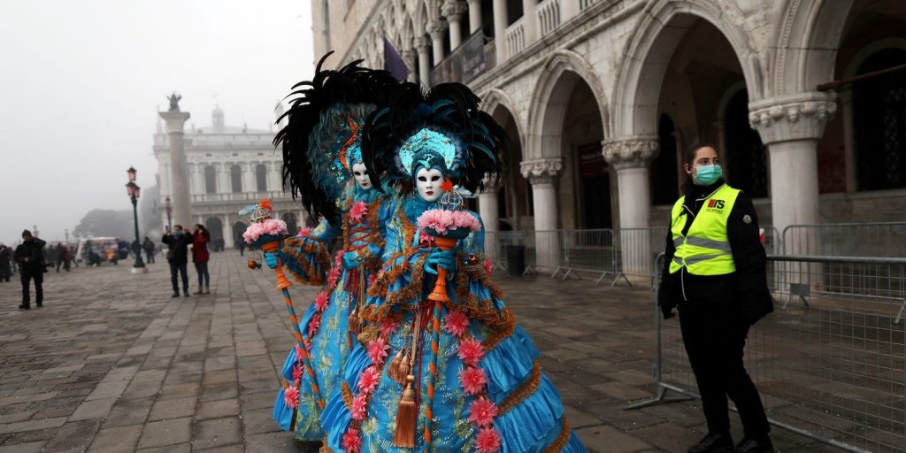 A policewoman next to carnival revelers at Venice Carnival. Ohad Zwigenberg Reuters